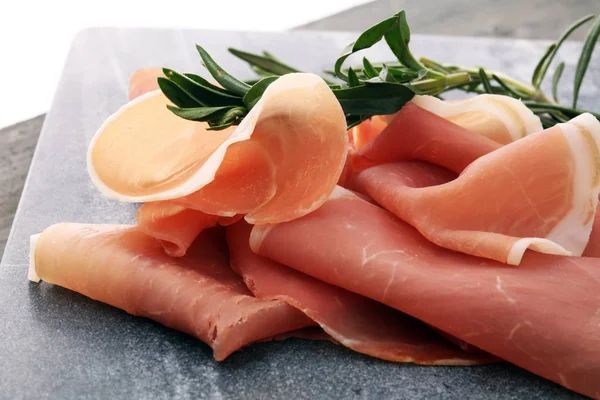 Crudo prosciutto italiano ou jamon com alecrim. Presunto cru em madeira — Fotografia de Stock