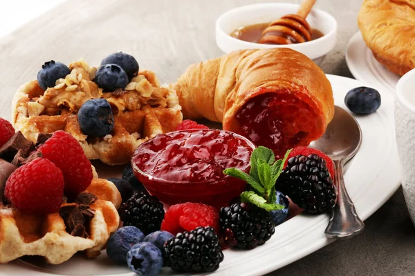 Heerlijk ontbijt met verse croissants en rijpe bessen en j — Stockfoto