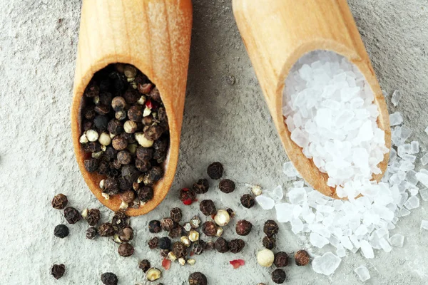 Ruwe zout en gemengde peperkorrels op houten schoppen — Stockfoto