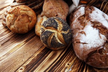 Ekmek ve ekmek çeşitleri ahşap arka plan üzerinde rulo. K