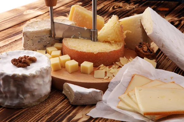 Vari tipi di formaggio su tavolo di legno rustico. piatto di formaggio — Foto Stock