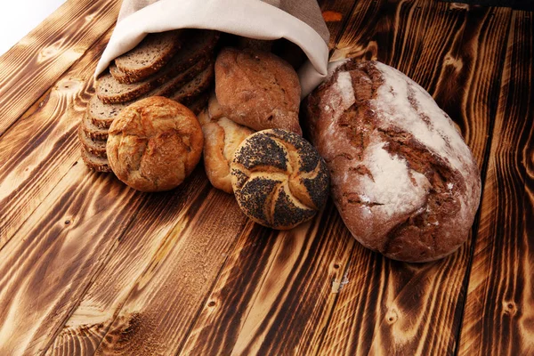 Diversi tipi di pane e panini su sfondo di legno. K — Foto Stock