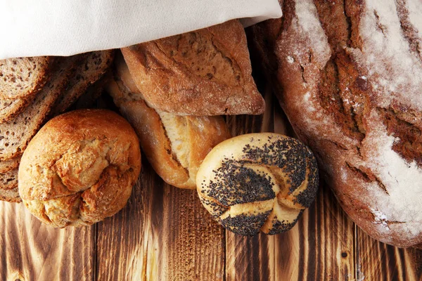 Verschiedene Arten von Brot und Brötchen auf Holzuntergrund. k — Stockfoto