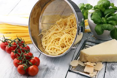 Spagetti makarna domates ve fesleğen ve ahşap bac üzerinde parmesan ile
