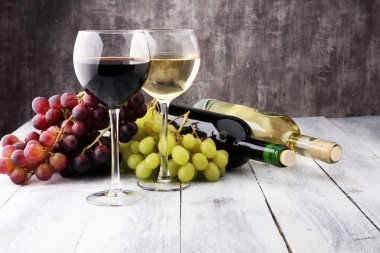 Glasses of wine and grapes on wooden background. red and white w clipart