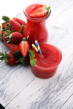 bardak çilek güler yüzlü ve bir wo üzerinde birçok taze çilek