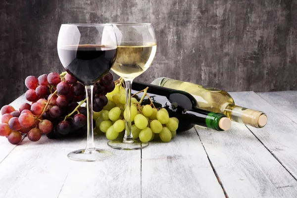 Ποτήρια κρασιού και σταφίδας σε ξύλινο υπόβαθρο. κόκκινο και λευκό w — Φωτογραφία Αρχείου
