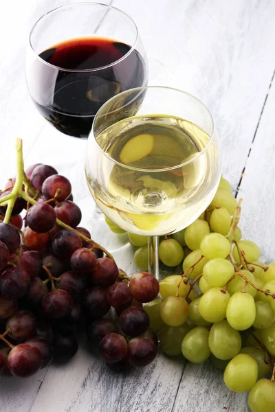 Copos de vinho e uvas sobre fundo de madeira. vermelho e branco w — Fotografia de Stock