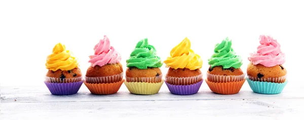 Cupcakes saborosos no fundo de madeira. Bolo de aniversário em arco-íris — Fotografia de Stock