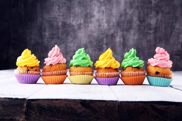 Tasty cupcakes on wooden background. Birthday cupcake in rainbow — Stock Photo, Image