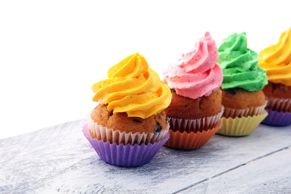 Chutné koláčky na dřevěné pozadí. Narozenin košíček v rainbow — Stock fotografie