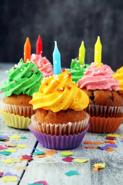 Cupcakes saborosos no fundo de madeira. Bolo de aniversário em arco-íris — Fotografia de Stock