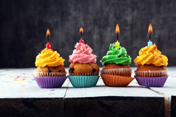 Cupcakes saborosos no fundo de madeira. Bolo de aniversário em arco-íris — Fotografia de Stock