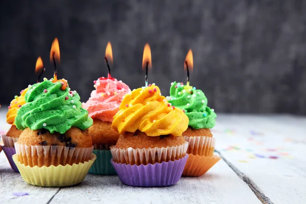 Cupcakes saborosos no fundo de madeira. Bolo de aniversário em arco-íris — Fotografia de Stock