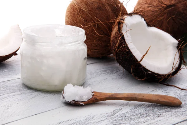 Kokos och öppnad glasburk med färsk kokos olja på trä ba — Stockfoto