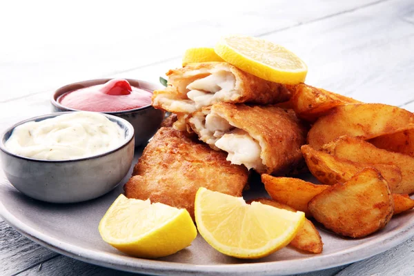 Peixe e batatas fritas britânicos tradicionais com batata e limão . — Fotografia de Stock
