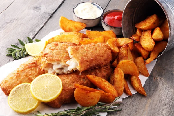 Peixe e batatas fritas britânicos tradicionais com batata e limão . — Fotografia de Stock