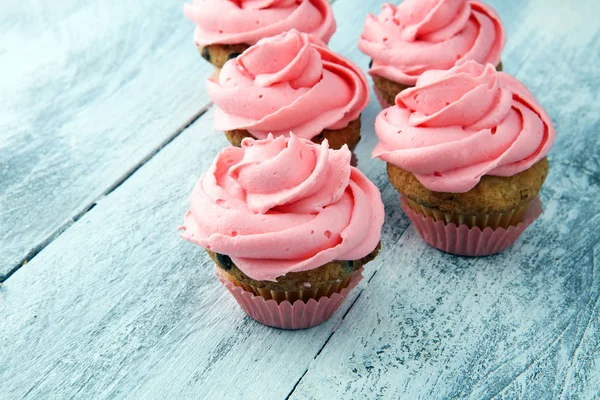 Sabrosos cupcakes sobre fondo de madera. Magdalena de cumpleaños en rosa co —  Fotos de Stock