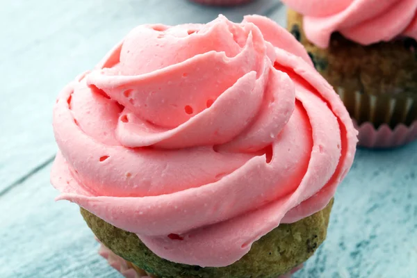 Cupcakes saborosos no fundo de madeira. Bolo de aniversário em co rosa — Fotografia de Stock