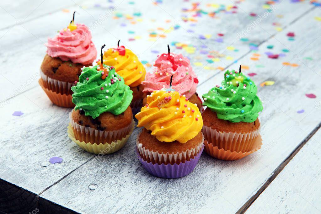 Tasty cupcakes on wooden background. Birthday cupcake in rainbow
