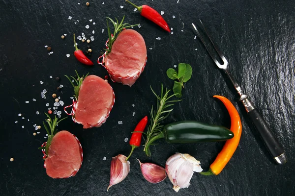 Raw beef fillet steaks mignon on dark background — Stock Photo, Image
