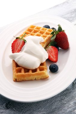 Çırpılmış krema ve taze çilek ile Belçika waffle tabak.