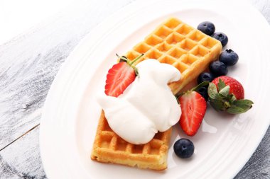 Çırpılmış krema ve taze çilek ile Belçika waffle tabak.