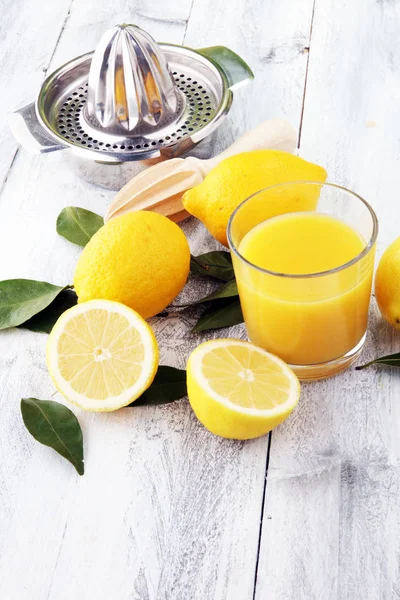 Склянка лимонного соку і скибочки апельсинових фруктів на дерев'яному фоні — стокове фото