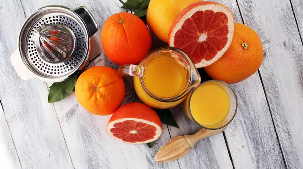Склянка грейпфрутового соку і скибочки апельсинових фруктів на дерев'яній б — стокове фото