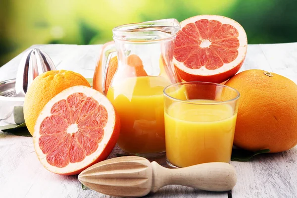 Bardak greyfurt suyu ve ahşap b turuncu meyve dilimleri — Stok fotoğraf