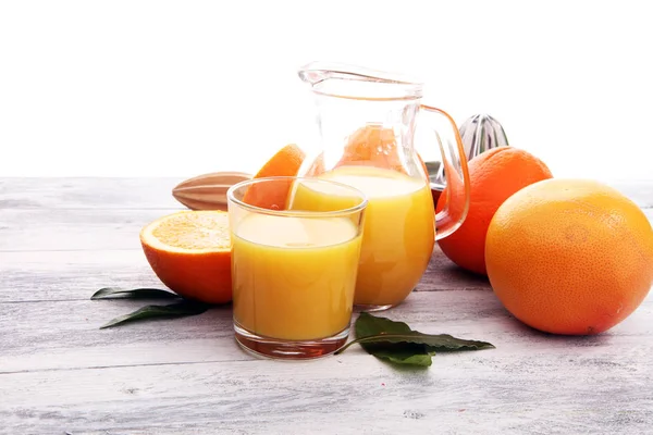 Склянка апельсинового соку і скибочки апельсинових фруктів на дерев'яному фоні — стокове фото