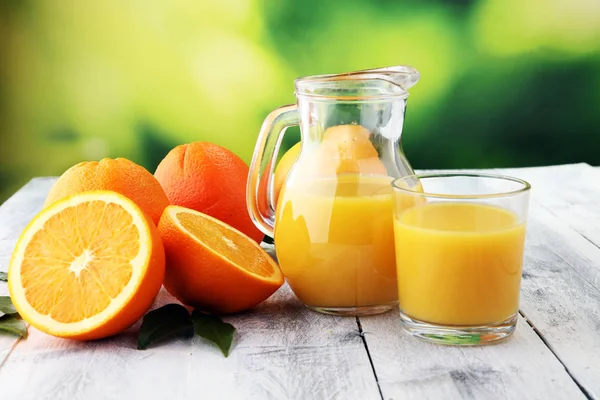 Glass of orange juice and slices of orange fruit on wooden backg — Stock Photo, Image