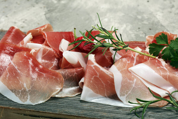 Italian prosciutto crudo or jamon with rosemary. Raw ham