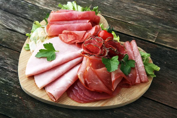 Food tray with delicious salami, pieces of sliced ham, sausage, — Stock Photo, Image