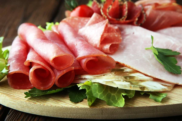 Bandeja de comida con delicioso salami, trozos de jamón en rodajas, salchicha, — Foto de Stock