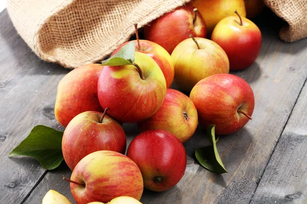 Pommes rouges mûres avec des feuilles sur fond en bois . — Photo