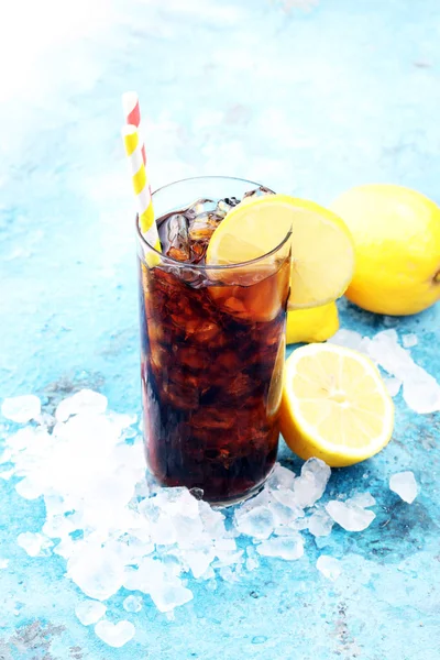 Softdrink com cubos de gelo, limão e palha em vidro. — Fotografia de Stock