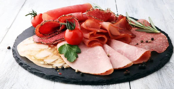 Food tray with delicious salami, pieces of sliced ham, sausage, — Stock Photo, Image