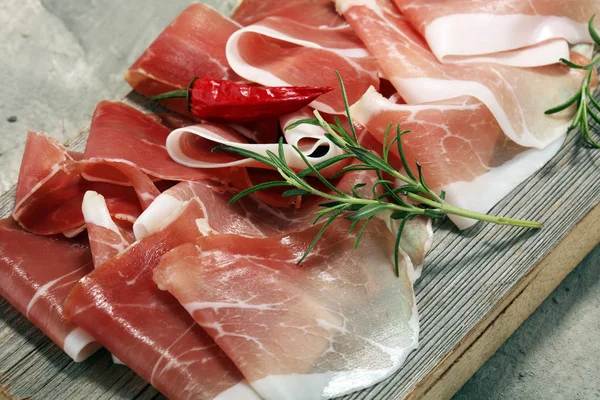 Italiensk prosciutto crudo eller jamon med rosmarin. Rå skinka — Stockfoto