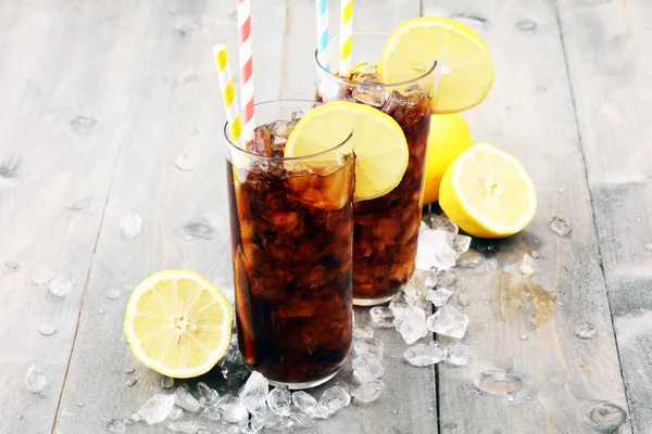 Softdrink with ice cubes, lemon and straw in glass. — Stock Photo, Image