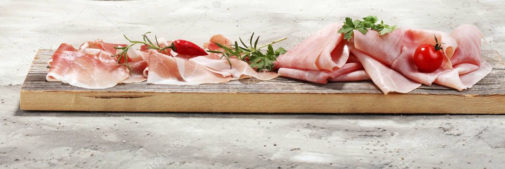 Italian prosciutto crudo or jamon with rosemary. Raw ham