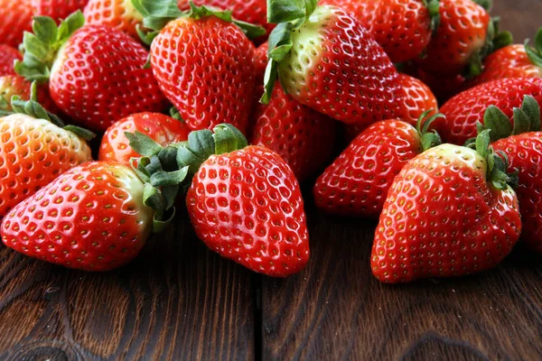 Fresh strawberries on brown wooden background. A group of strawb — Stock Photo, Image