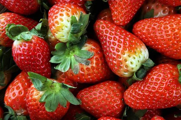 Fresh strawberries on brown wooden background. A group of strawb — Stock Photo, Image