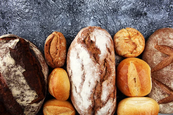 Olika sorters bröd och bröd rullar ombord från ovan. KI — Stockfoto