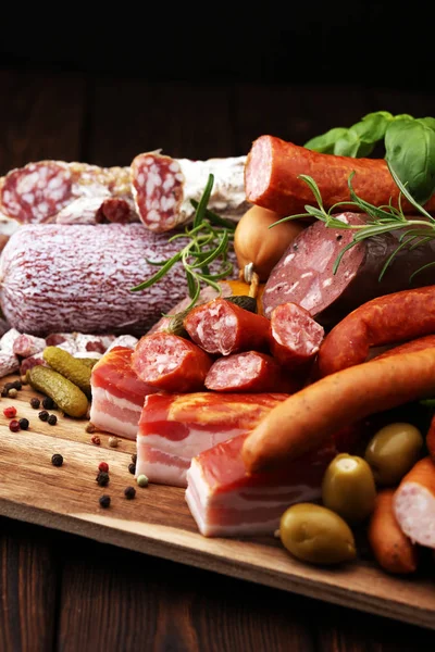 Food tray with delicious salami, ham,  fresh sausages, cucumber Royalty Free Stock Images