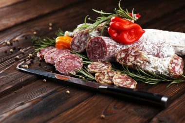 ince dilimlenmiş Salam bir ahşap doku ve arka plan üzerinde.