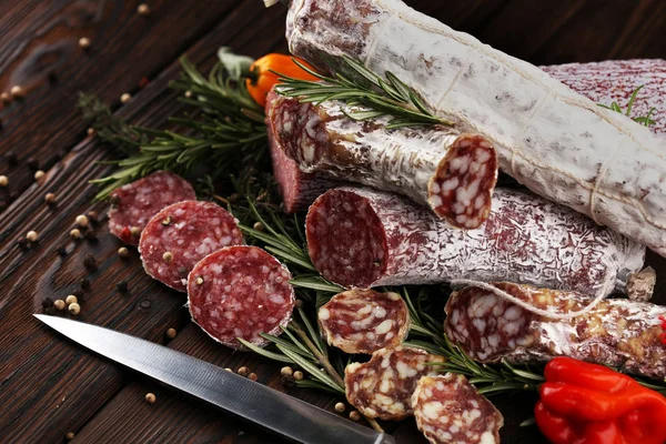 Salami en rodajas finas sobre una textura de madera en el fondo . — Foto de Stock