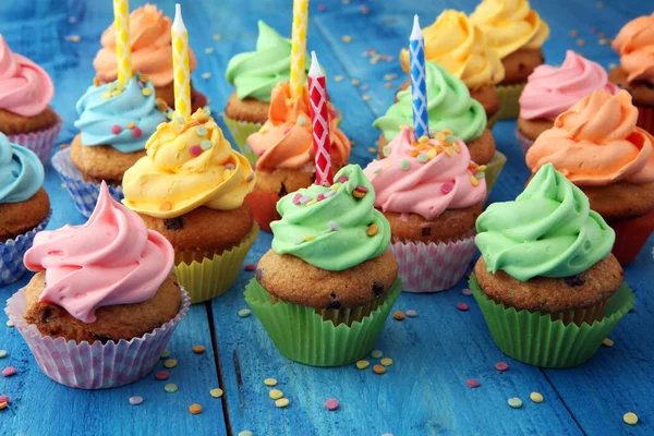 Cupcakes saborosos no fundo de madeira. Bolo de aniversário em arco-íris — Fotografia de Stock