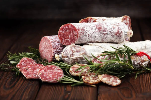 Tyndt skåret salami på en træstruktur på baggrunden . - Stock-foto