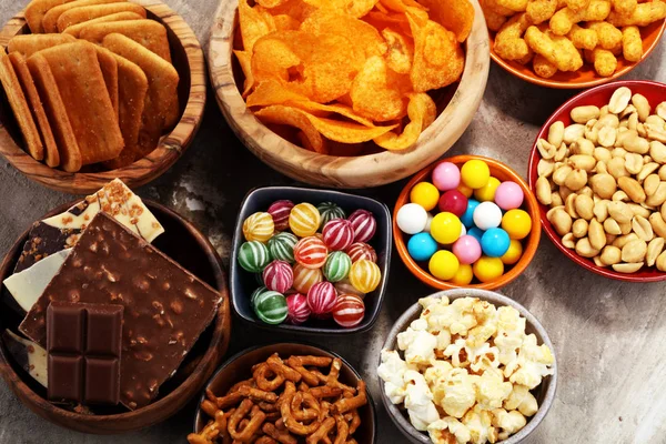 Salty snacks. Pretzels, chips, crackers in wooden bowls. — Stock Photo, Image